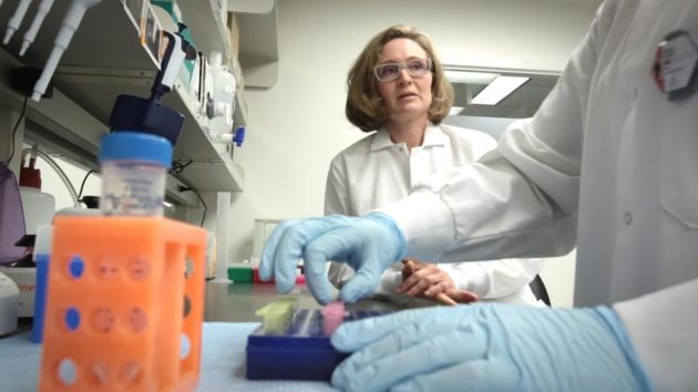Fred Hutch researcher and one of the trial's leads Dr. Aude Chapuis looks on as a lab technician prepares samples. (Fred Hutch Photo) 