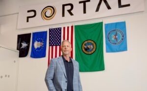 Jeff Thornburg with Portal logo and flags posted on the wall behind him