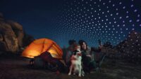 Campers looking at a smartphone with tent and streams of "Leo" logos in background
