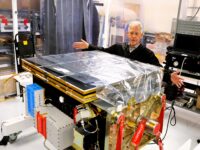 Portal CEO Jeff Thornburg stretching arms out to show Starburst-1 satellite in Bothell lab