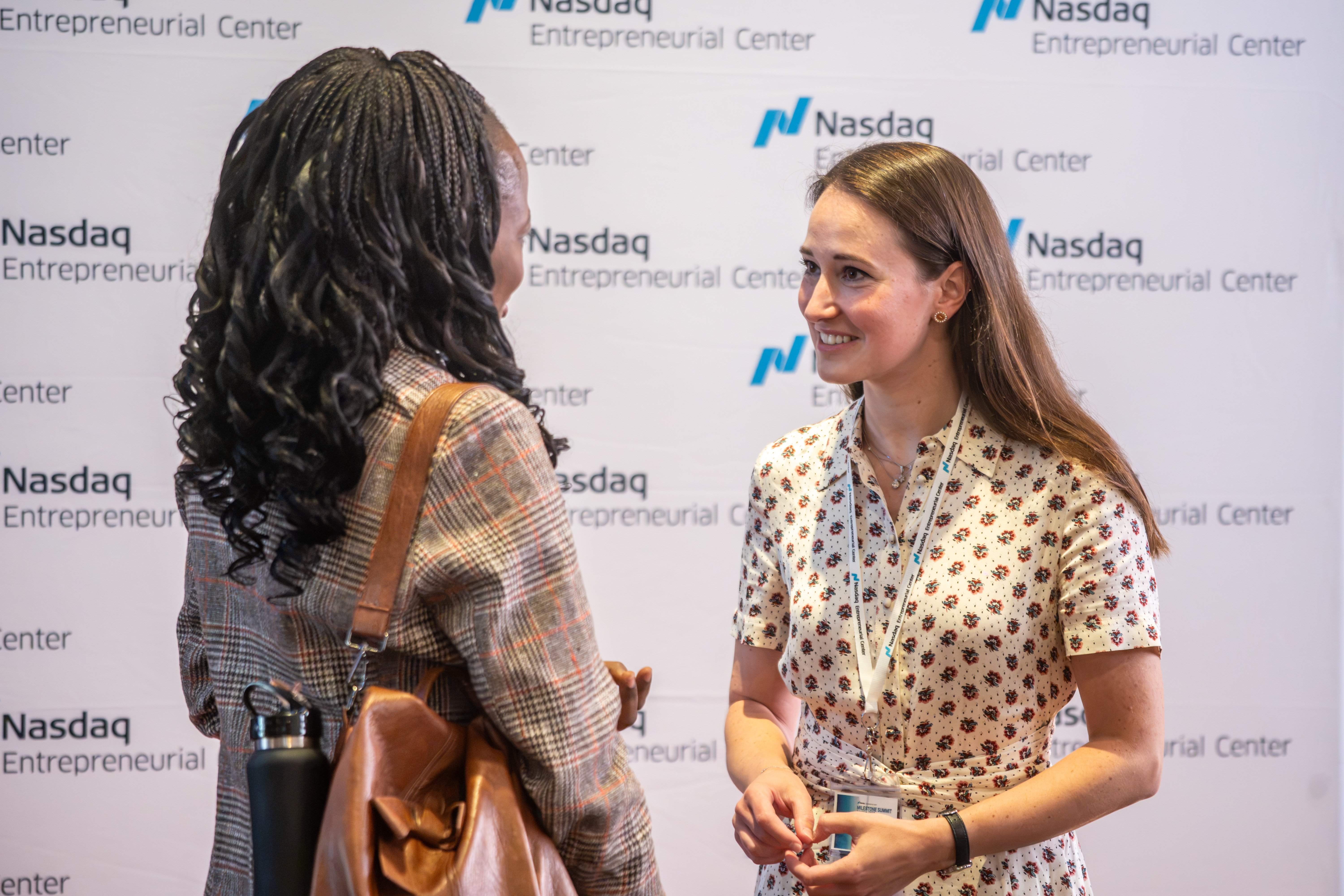 Attendees networking at the Nasdaq Milestone Summit step-and-repeat
