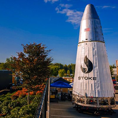 Stoke Space's Nova second stage sitting in open area surrounded by buildings and trees
