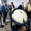 Space Northwest Symposium attendees in the lobby of a conference hall with Varda space capsule on display