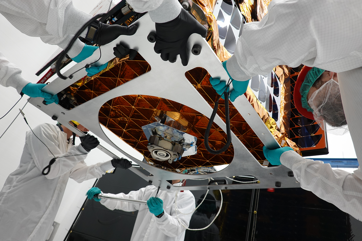 Workers wearing lab coats position Otter, as viewed from below
