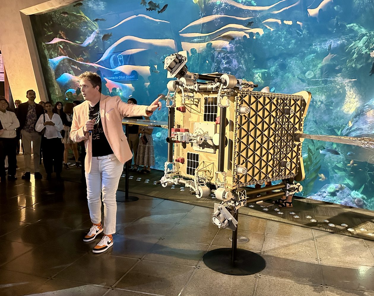 Austin Link gestures toward Otter replica at Seattle Aquarium