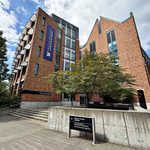 The Paul G. Allen Center, a brick building with a banner for the Paul G. Allen School of Computer Science & Engineering, on the University of Washington campus.