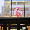 The red F5 logo displayed behind glass above the entrance to F5 Tower in Seattle