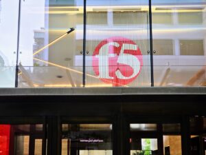 The red F5 logo displayed behind glass above the entrance to F5 Tower in Seattle