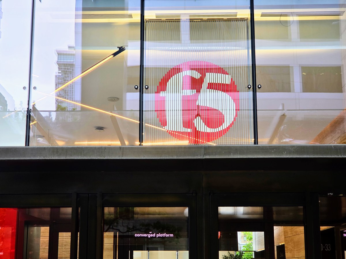 The red F5 logo displayed behind glass above the entrance to F5 Tower in Seattle