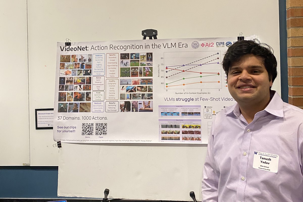 A student in a lavender shirt stands beside a research poster