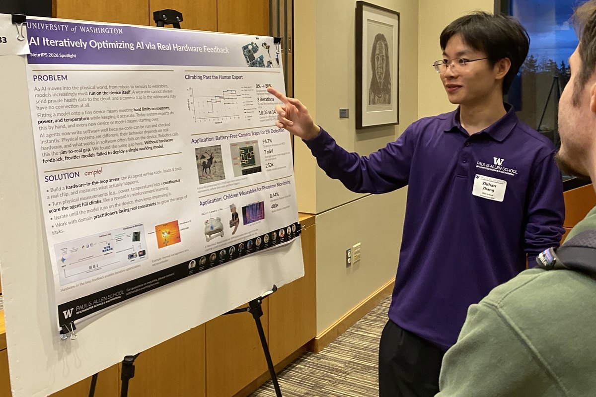 A student in a purple shirt points to a research poster